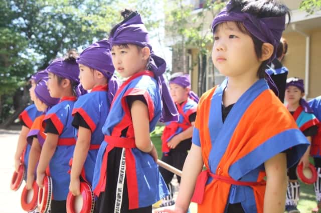 園児達が野外でエイサー衣装を着て並んでいる写真
