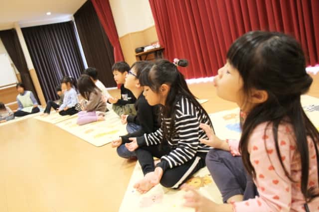 園児達が足の裏を合わせて座り手を膝の上に置いて目を瞑っている写真