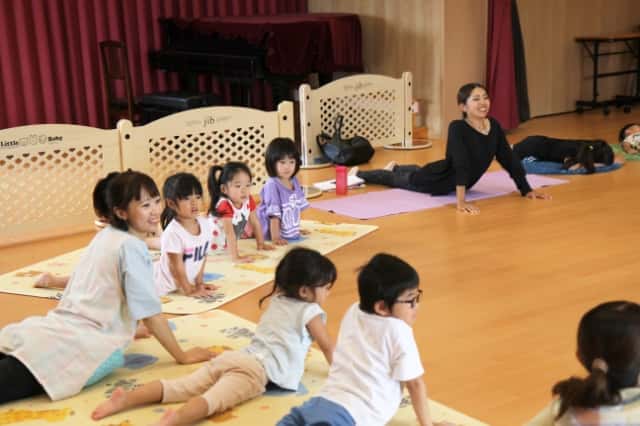 先生と園児達がうつ伏せになり両腕を床につけて体を逸らせている写真
