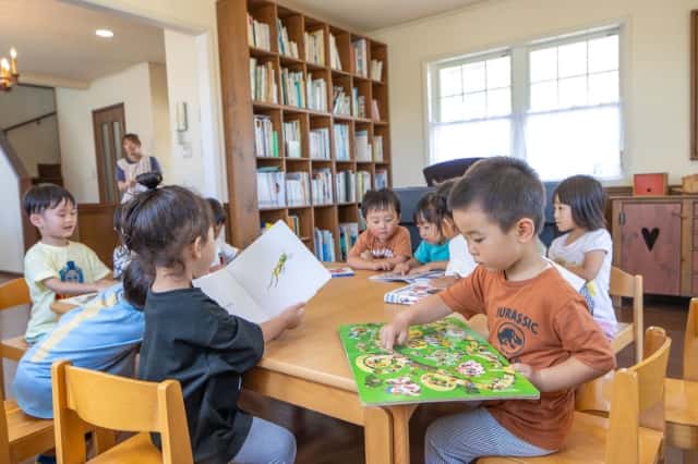 園児達が机で絵本を読んでいる写真